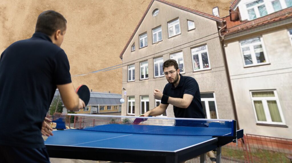 Dwóch mężczyzn gra w tenisa stołowego.