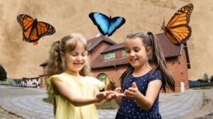 Dwie dziewczynki trzymające motyla na dłoniach.