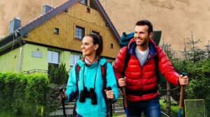 Para turystów idących w kierunku schroniska górskiego.