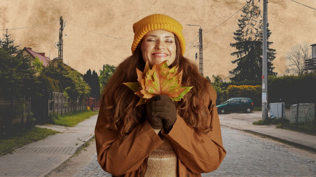 Uśmiechnięta kobieta trzyma liście na tle ulicy