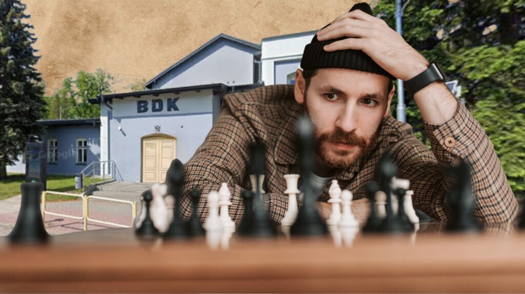 Mężczyzna grający w szachy w plenerze.