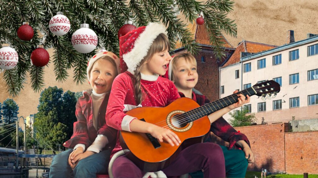 Dzieci w strojach świątecznych grają na gitarze.