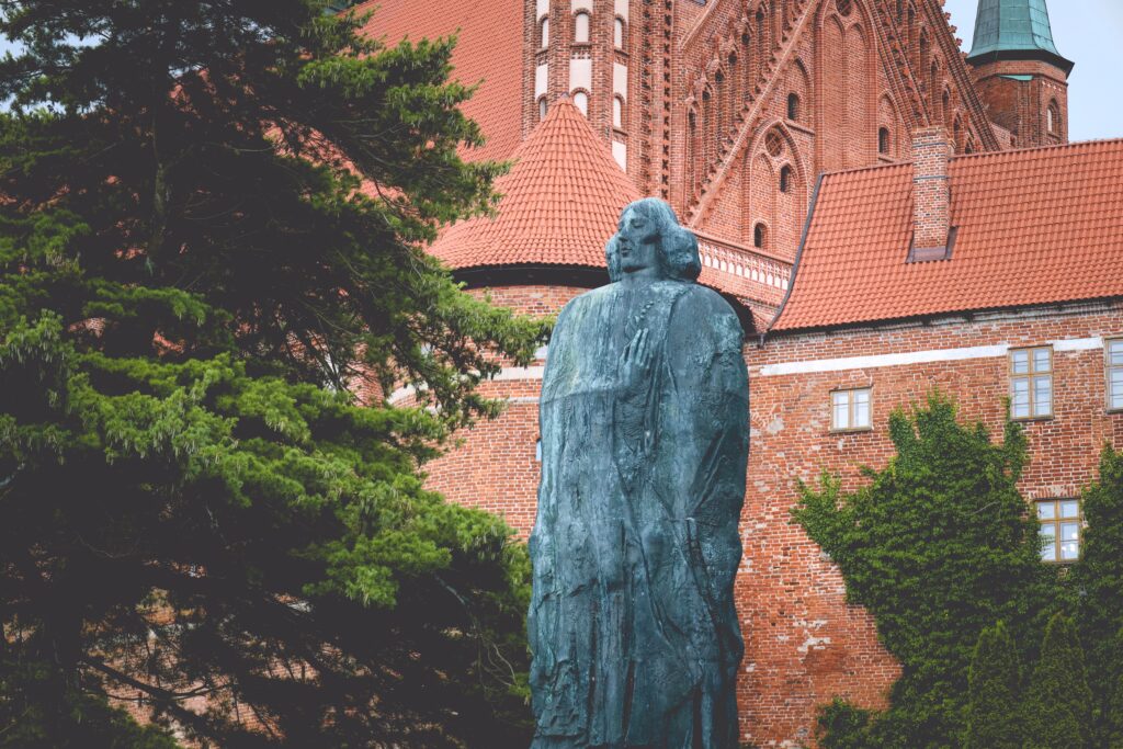 Pomnik mężczyzny w szacie przy czerwonej cegle