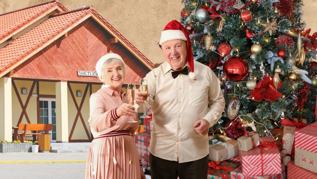 Para z kieliszkami przed choinką.