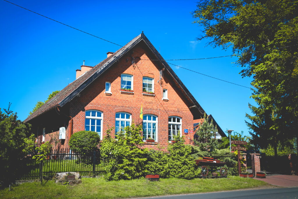 Czerwony dom z białymi oknami na tle nieba