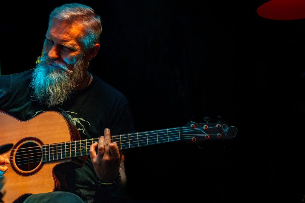 Mężczyzna grający na gitarze akustycznej.