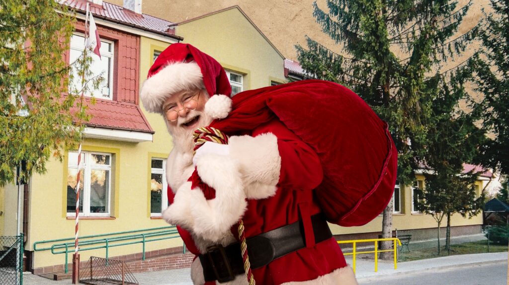 Święty Mikołaj z workiem prezentów przy budynku.