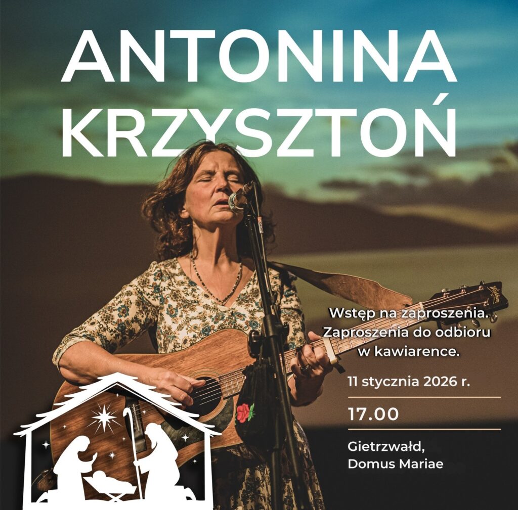 Kobieta śpiewa z gitarą na scenie.