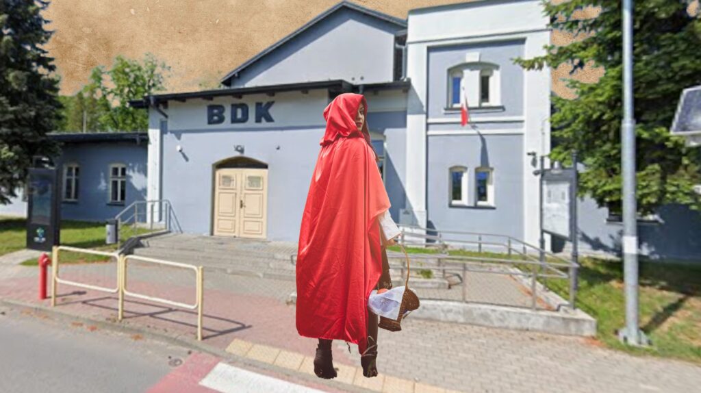 Osoba w czerwonym płaszczu idzie w stronę budynku BDK.