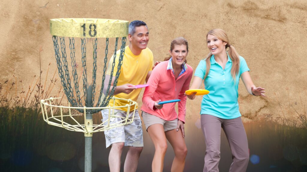 Trzy osoby grają w disc golf przy koszu.