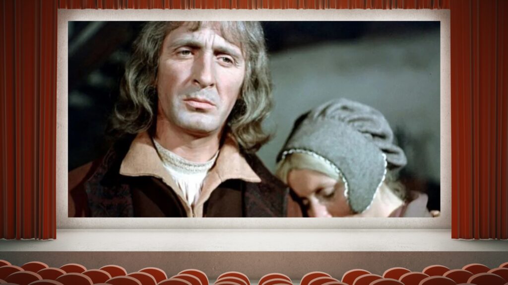 Mężczyzna z długimi włosami i kobieta w chustce w kinie.