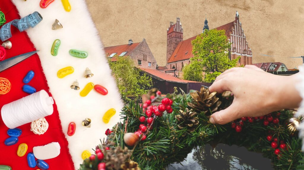 Ręka układająca dekoracje na wianek z jagodami i szyszkami.