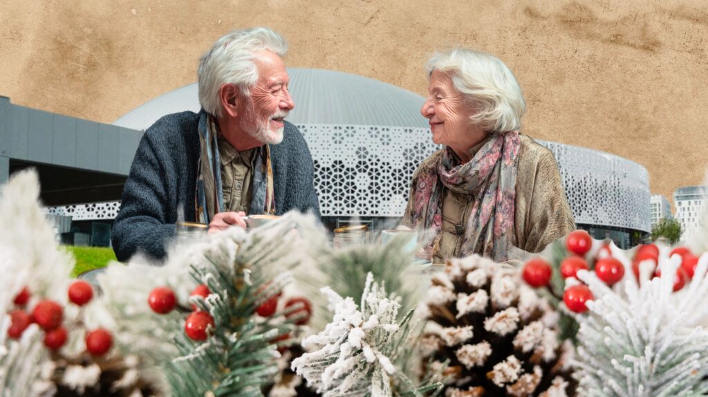 Starsza para uśmiechająca się przy stole z dekoracjami świątecznymi.