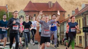 Biegacze uczestniczący w maratonie na tle miasta.