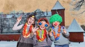 Troje dzieci w kolorowych przebraniu z zabawnymi akcesoriami.