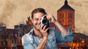 Mężczyzna w denimie trzyma aparat fotograficzny.