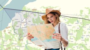 Kobieta trzymająca mapę w rękach, z widokiem na mapę w tle.