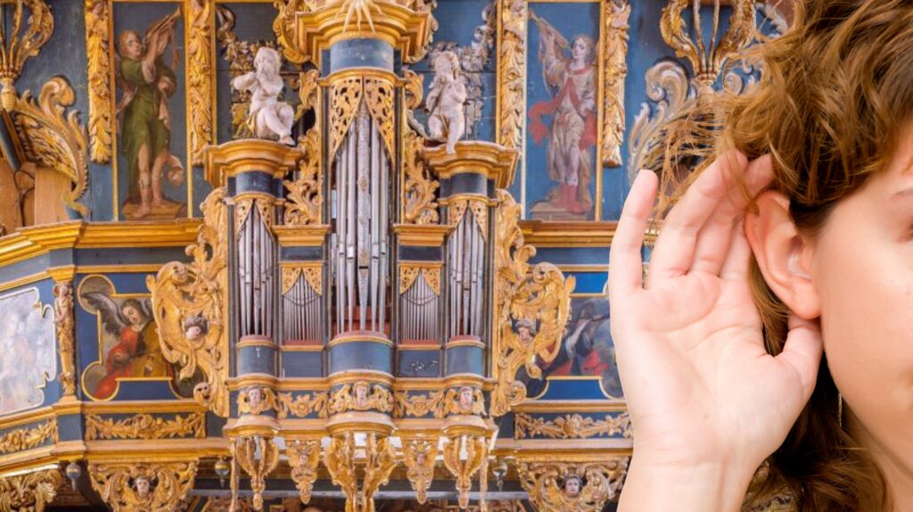 Osoba trzyma rękę przy uchu, w tle organ.