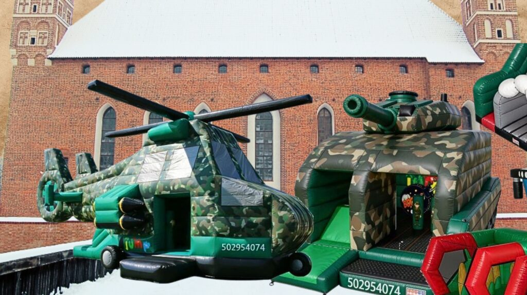 Dmuchany helikopter i czołg na tle zabytkowego budynku.