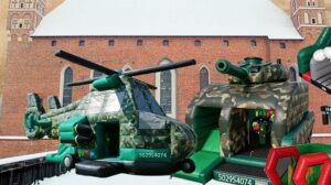Dmuchany helikopter i czołg na tle zabytkowego budynku.
