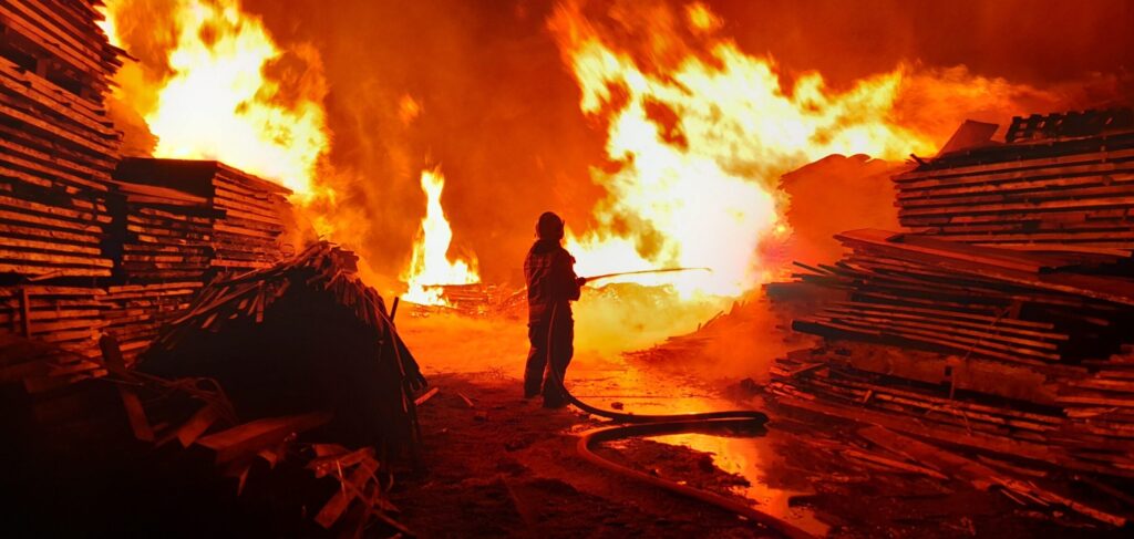 Strażak walczący z ogniem w drewnianej strefie.