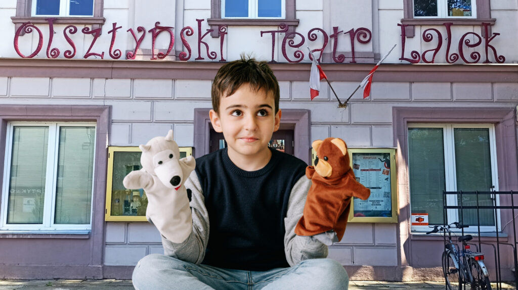 Chłopiec trzyma lalki w Olsztyńskim Teatrze Lalek.