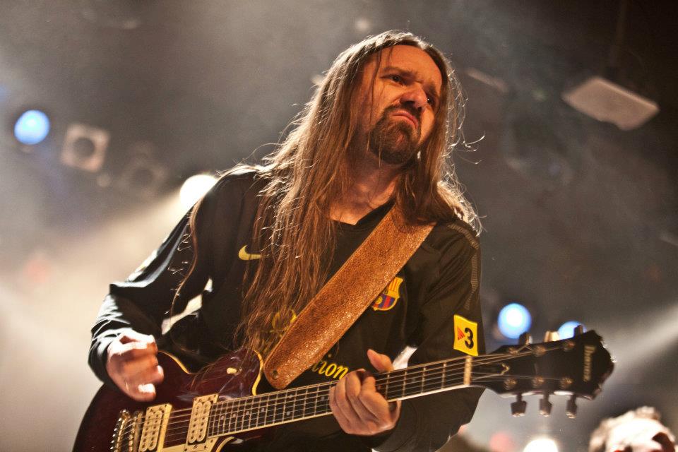 Muzyk grający na gitarze elektrycznej na scenie.