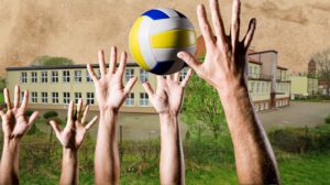Ręce podnoszące piłkę siatkową przed szkołą.