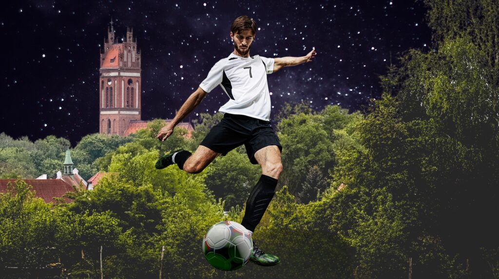 Mężczyzna kopiący piłkę na tle przyrody.