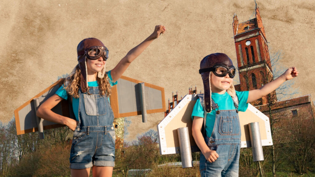 Dzieci w strojach pilota z tekturowymi skrzydłami.