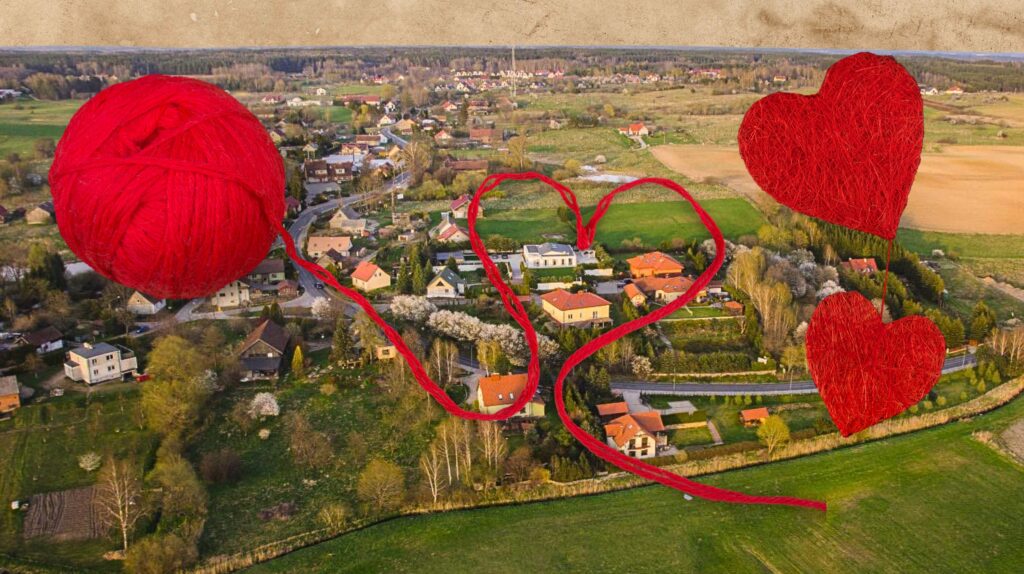 Widok na malowniczą wieś z czerwonym włóczką w kształcie serc.