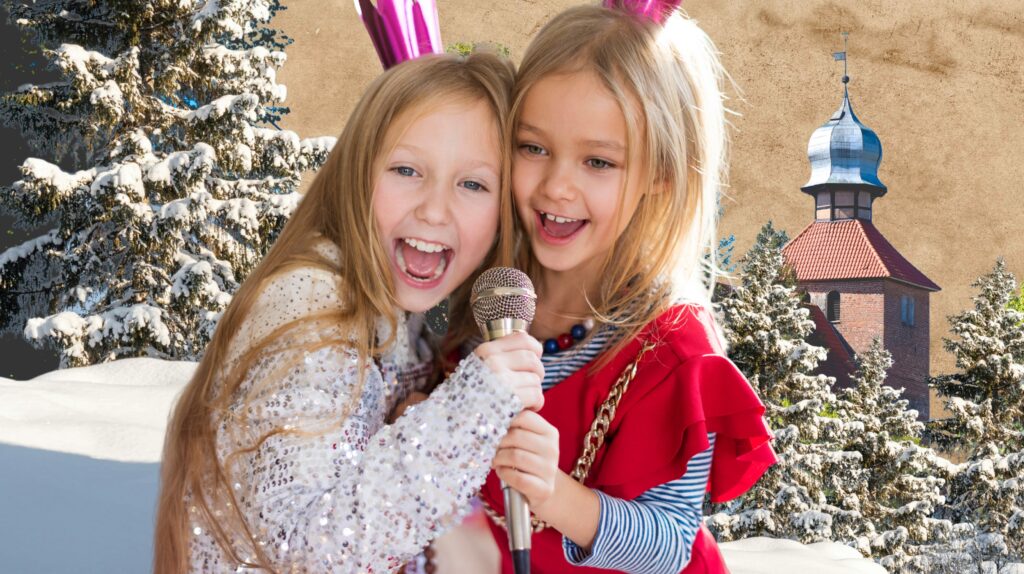 Dwie uśmiechnięte dziewczynki trzymają mikrofon w zimowej scenerii.