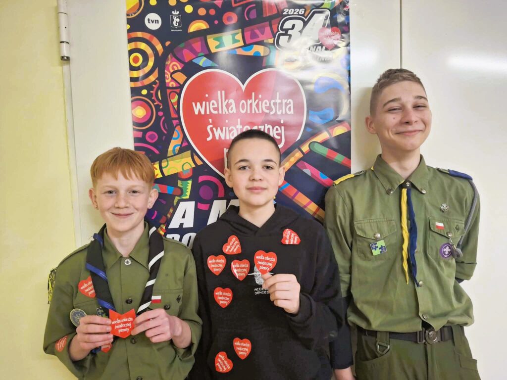 Trójka dzieci w mundurach z serduszkami WOŚP.