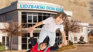 Dzieci bawią się przed budynkiem.