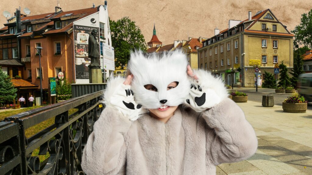 Dziecko w maski kota na tle miasta.