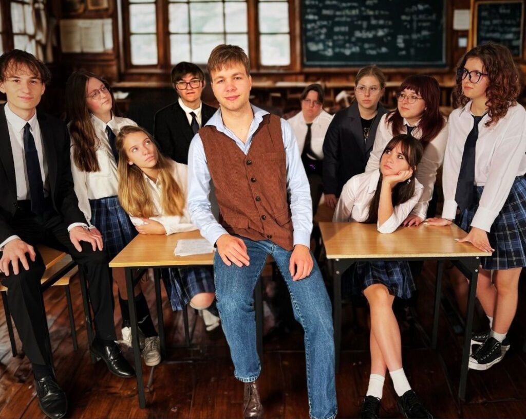 Grupa uczniów w sali lekcyjnej.