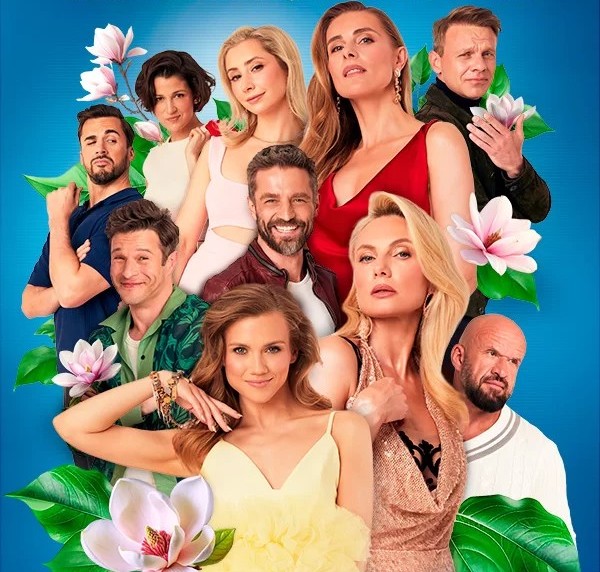 Grupa ludzi w kolorowych strojach z elementami florystycznymi w tle.