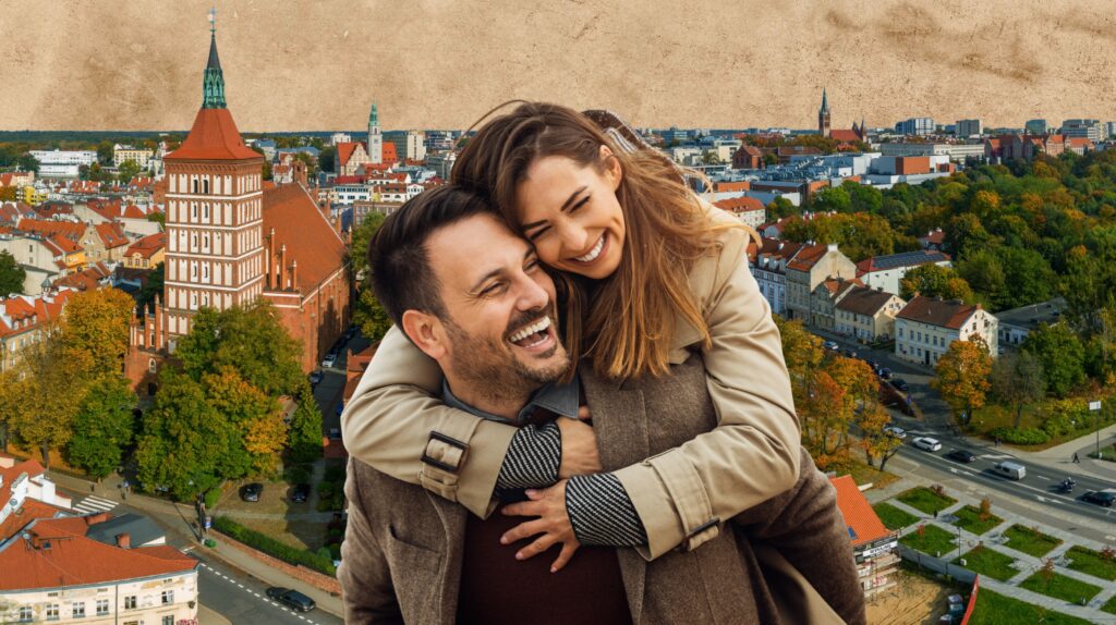 Pozująca na tle miasto para uśmiechniętych osób.