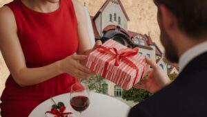 Kobieta wręczająca prezent mężczyźnie.