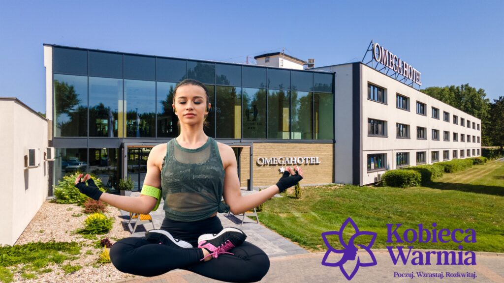 Młoda kobieta medytująca w pozycji lotosu na tle hotelu Omega w Olsztynie.