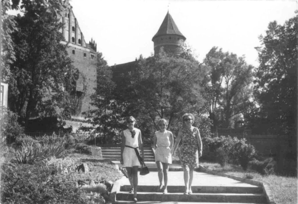 Trzy kobiety spacerujące w parku.