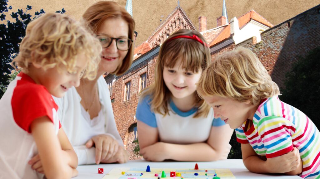 Dzieci i dorosła osoba grają w planszową grę.