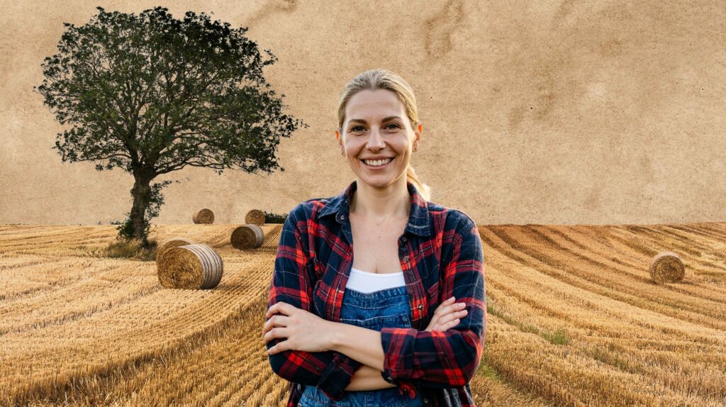Uśmiechnięta kobieta w polu z sianem.