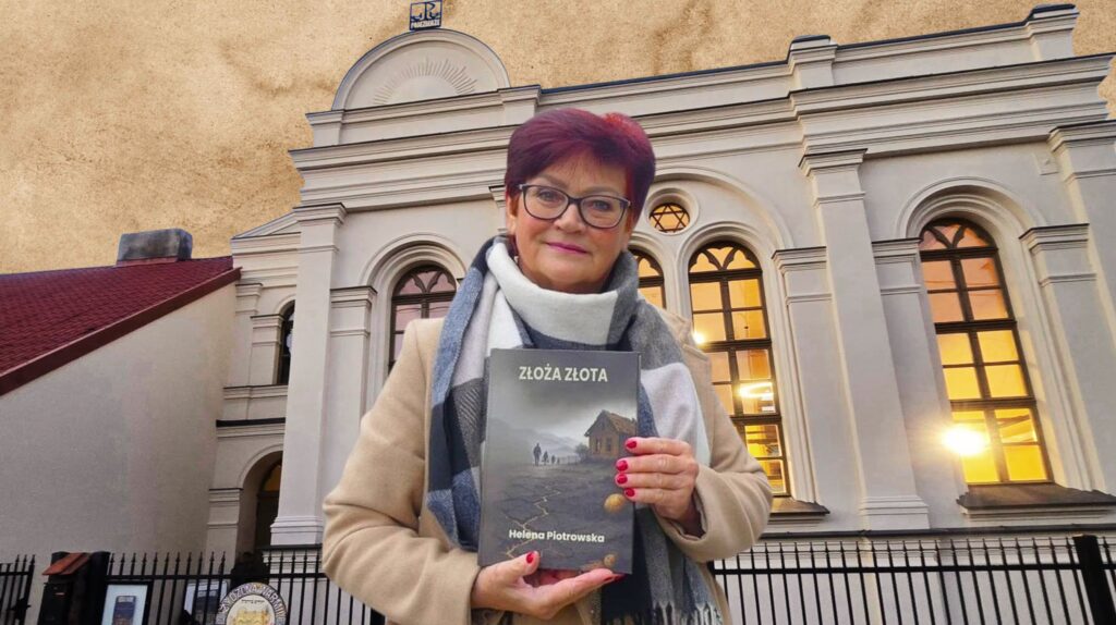 Kobieta trzymająca książkę przed budynkiem.