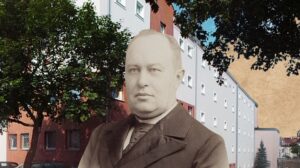 Mężczyzna w garniturze przed budynkiem.