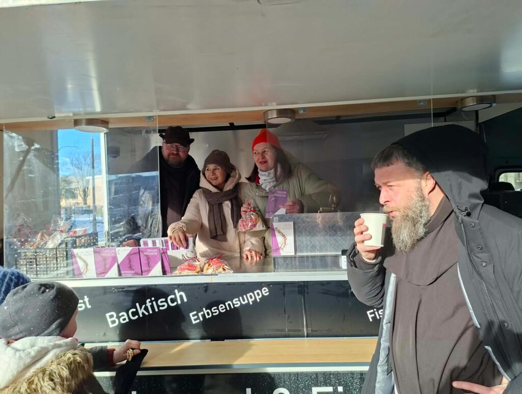Kiosk z jedzeniem, ludzie kupujący jedzenie.