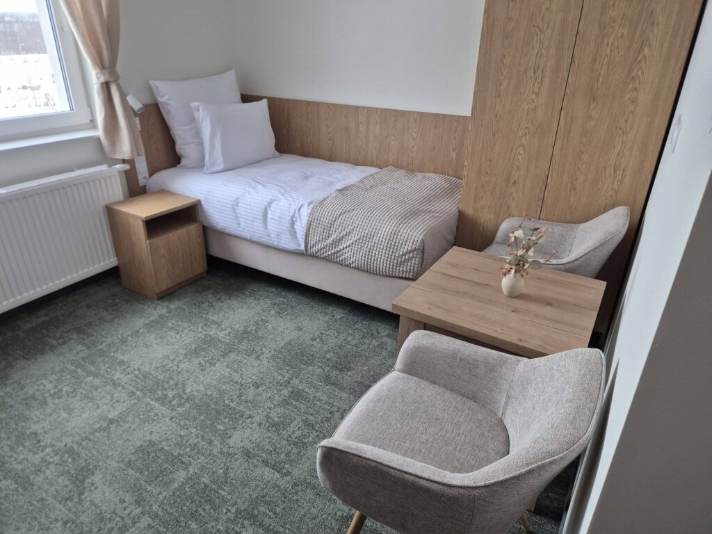 Mały, komfortowy pokój hotelowy z łóżkiem.