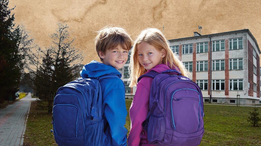 Dzieci z plecakami na tle szkoły