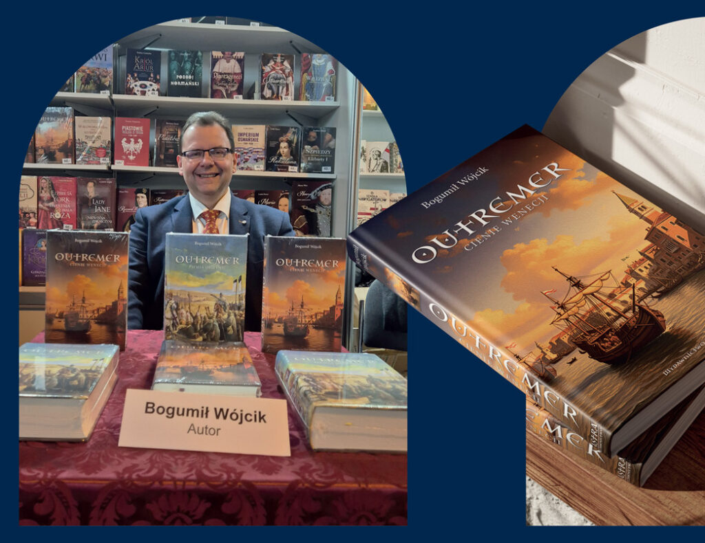 Autor Bogumił Wójcik przy stoisku z książkami.