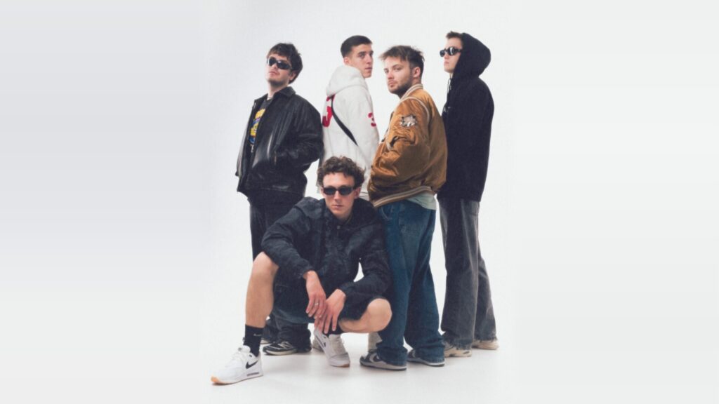 Pięciu młodych mężczyzn w okularach przeciwsłonecznych pozuje na białym tle